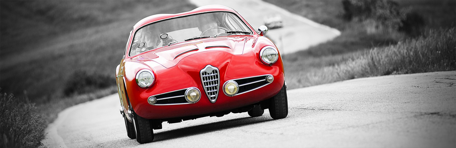 Alfa Romeo d&rsquo;epoca rossa su strada di collina